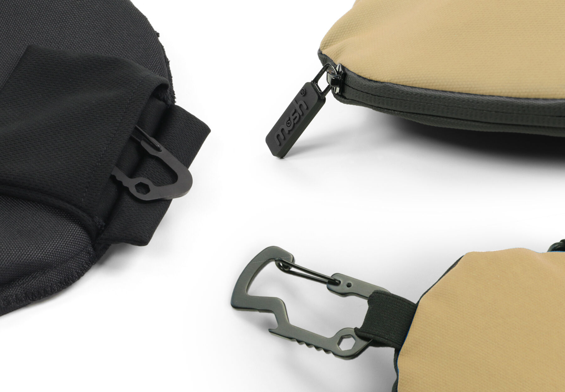 Nahaufnahme von zwei Taschen: eine schwarze und eine beige, mit Karabinerhaken und Reißverschluss.