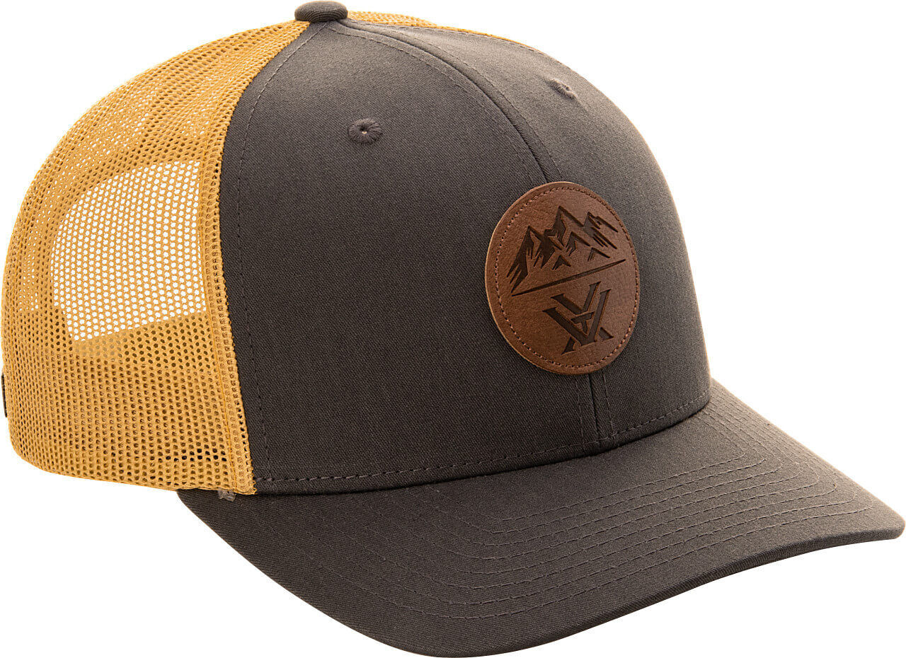 Trucker-Cap in Grau mit gelbem Mesh-Rückenteil und braunem Lederlogo mit Bergmotiv