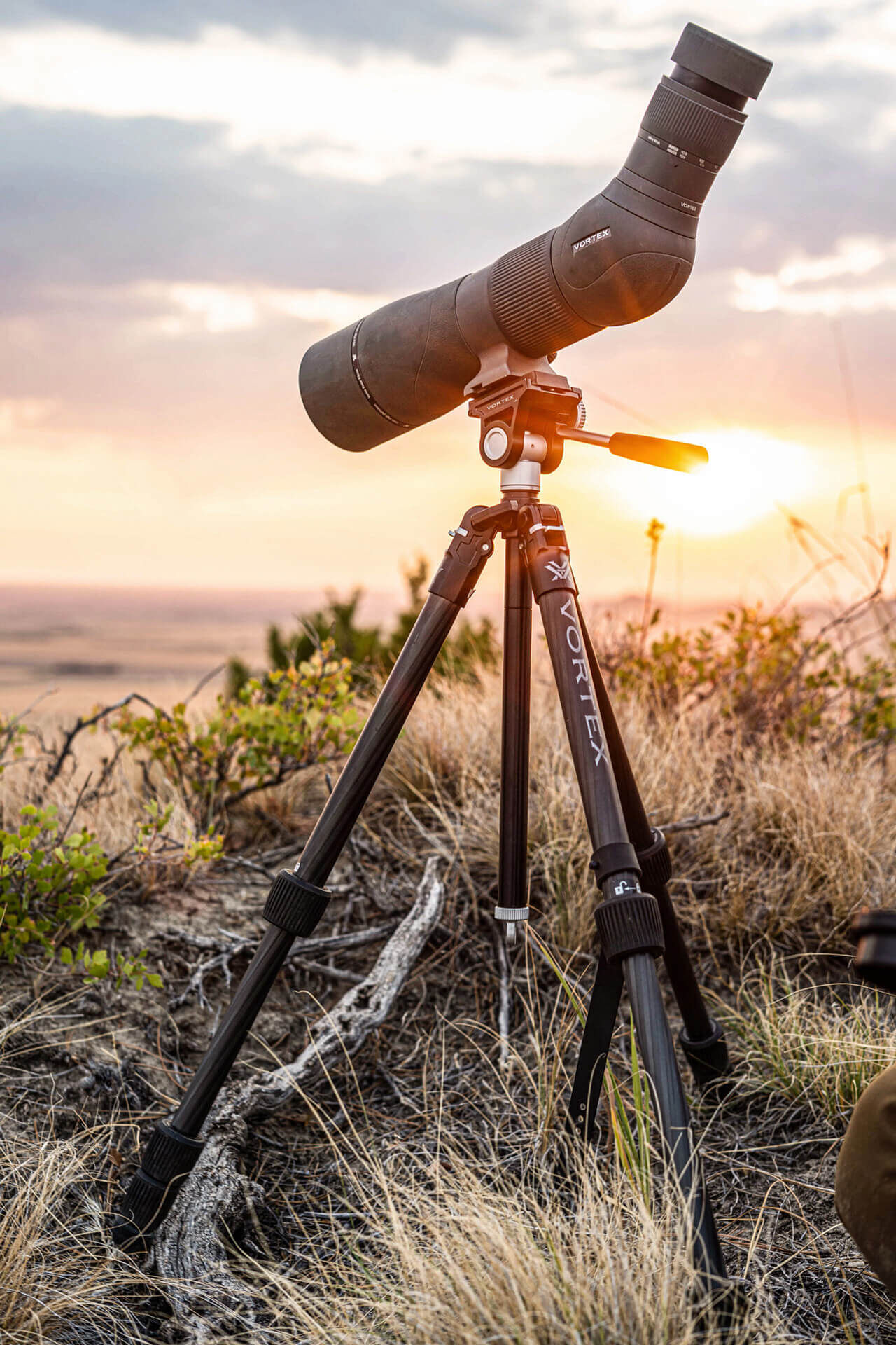 Stabiles Stativ mit Spektiv bei Sonnenuntergang in der Natur Ein Spektiv auf einem robusten Stativ steht in einer Naturlandschaft bei Sonnenuntergang