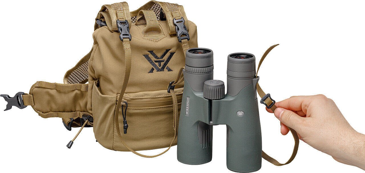 Hand hält wasserfestes Fernglas neben robustem Rucksack mit verstellbaren Gurten, ideal für Outdoor-Abenteuer