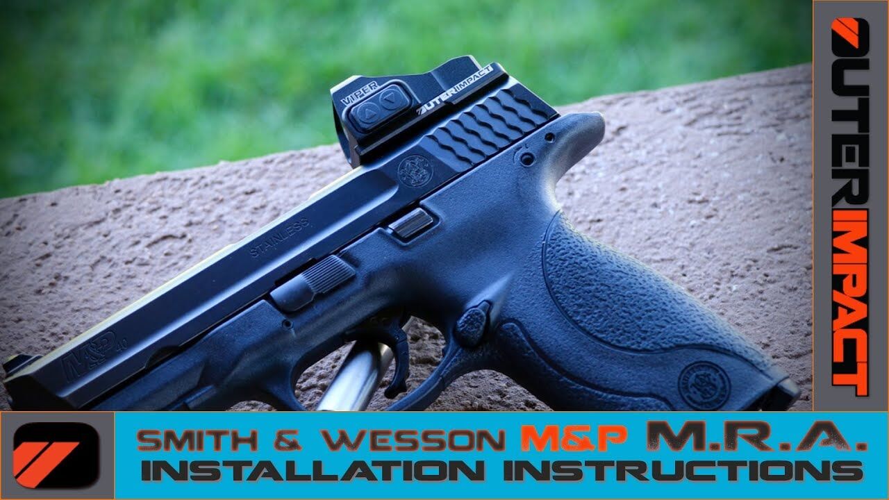 Nahaufnahme einer Smith & Wesson M&P mit montiertem Vortex Viper Rotpunktvisier auf einer stabilen Oberfläche, mit im Hintergrund unscharfem Grünbereich. Außenbereich-Montageanleitung für Waffenoptik.