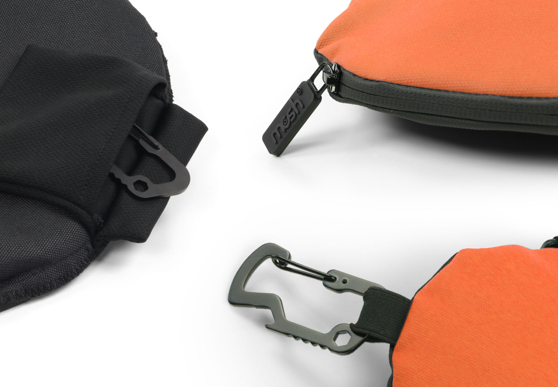 Detailansicht von zwei Taschen in Schwarz und Orange, ausgestattet mit robusten Karabinerhaken