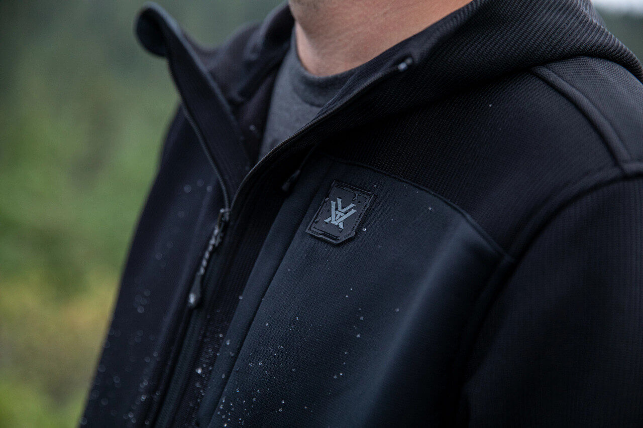 Nahaufnahme einer wasserdichten Outdoor-Jacke mit sichtbarem Logo und Reißverschluss, ideal für schlechtes Wetter.