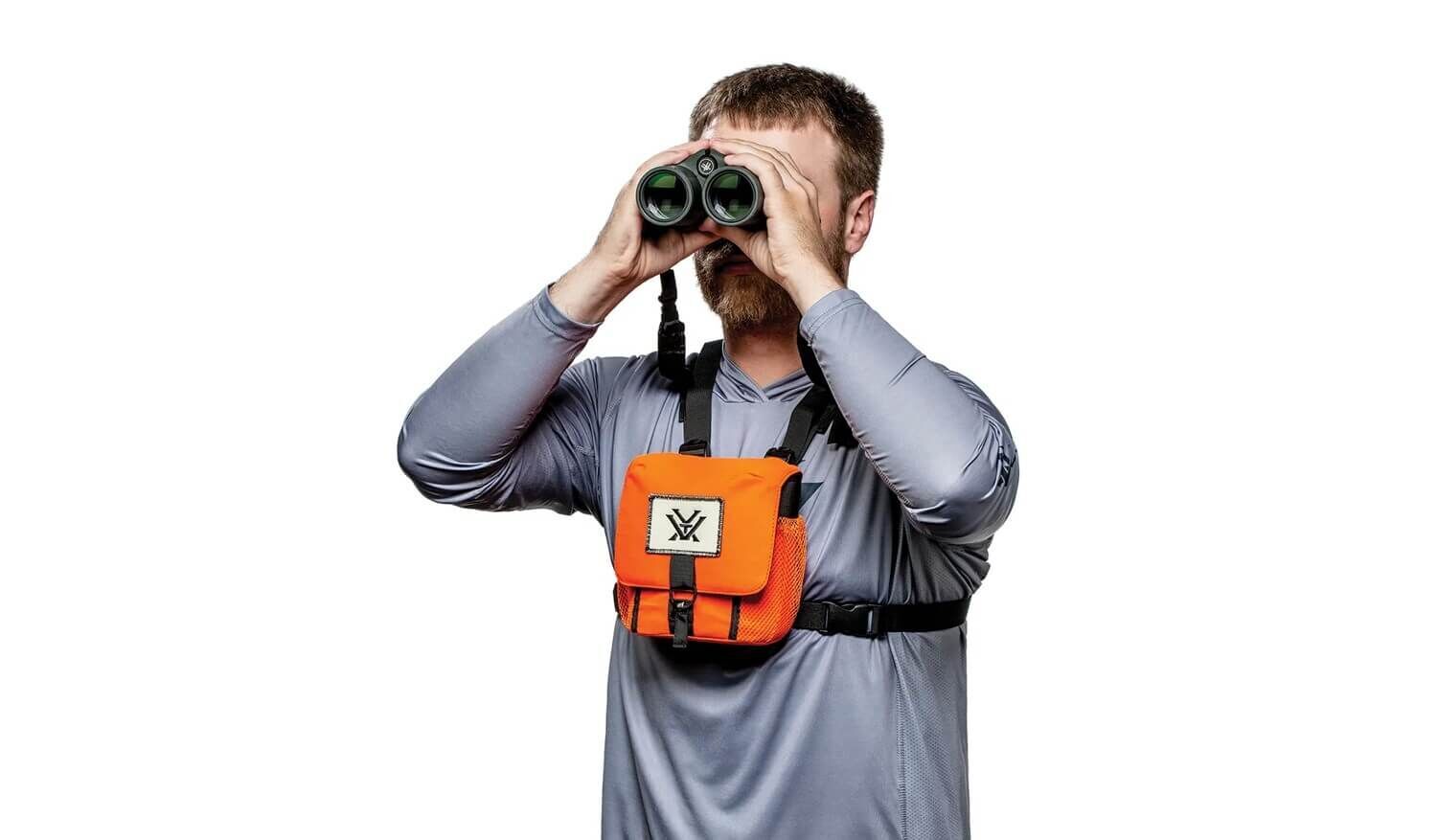 Ein Mann in grauem Shirt benutzt ein Fernglas und trägt eine orangefarbene Brusttasche.