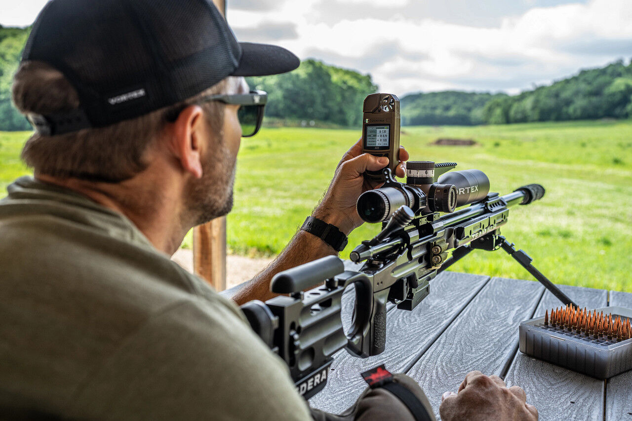 Schütze mit Präzisionsgewehr nutzt das Vortex Ace Ballistisches Wettermessgerät von Vortex, um Wind- und Wetterdaten für weite Schüsse in Echtzeit zu ermitteln