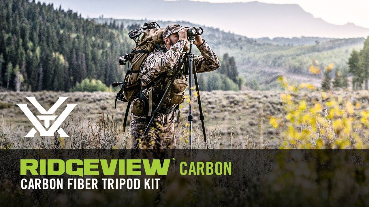 Jäger nutzt das Ridgeview Carbon Stativ-Set mit Fernglas in bewaldeter Landschaft
