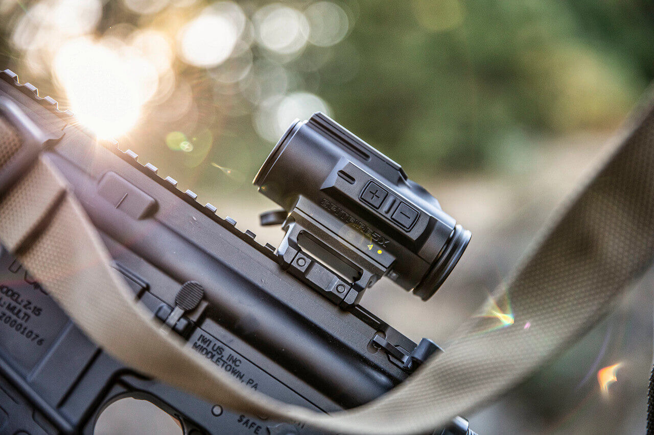 Nahaufnahme eines taktischen Zielfernrohrs auf einem Gewehr, Sonnenlicht im Hintergrund