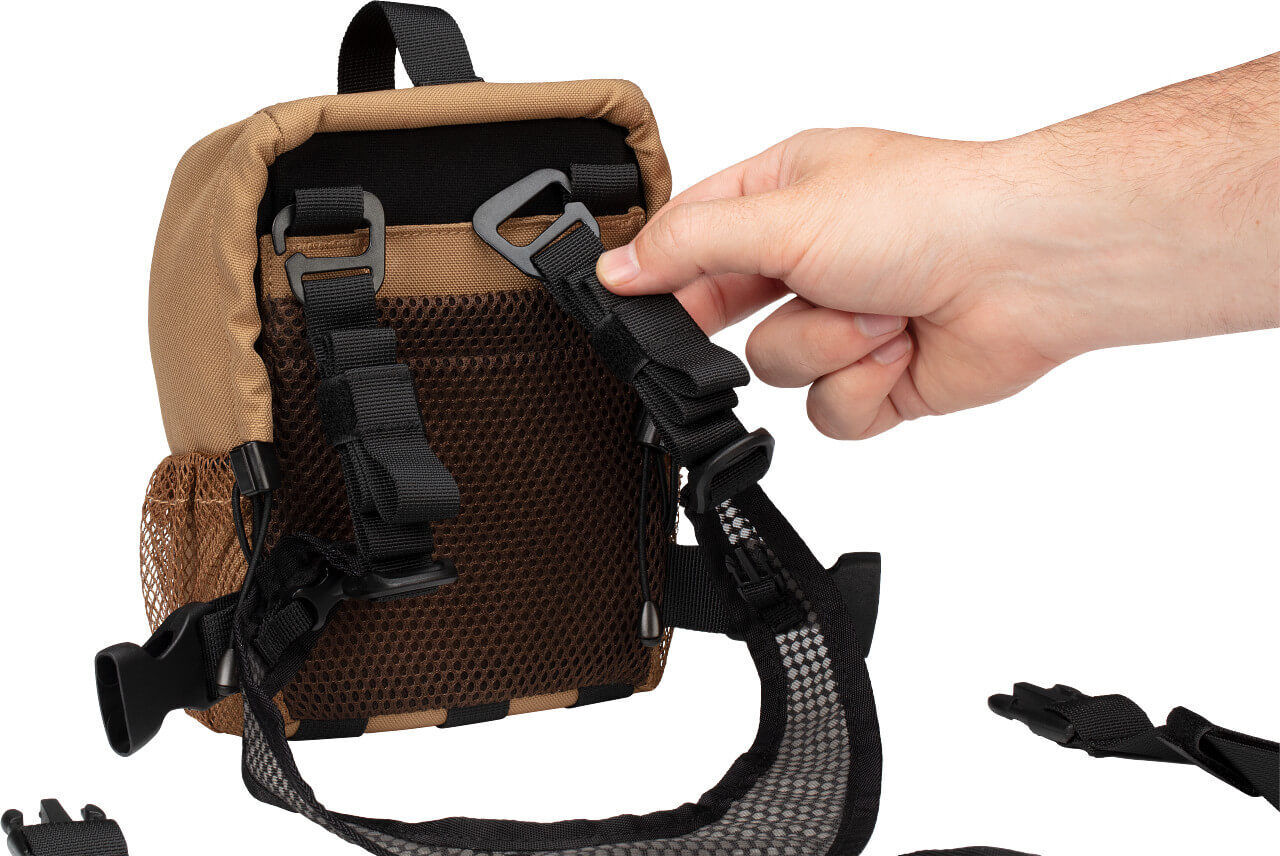 Hand justiert den verstellbaren Gurt einer braunen Mesh-Tasche