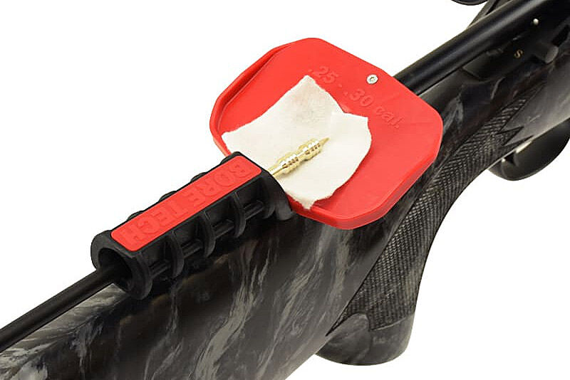 Laufreinigungszubehör von Bore-Tec an einem Gewehr: Reinigungsstock mit Patchhalter und roter Tropfschutzschale beim Säubern des Laufes